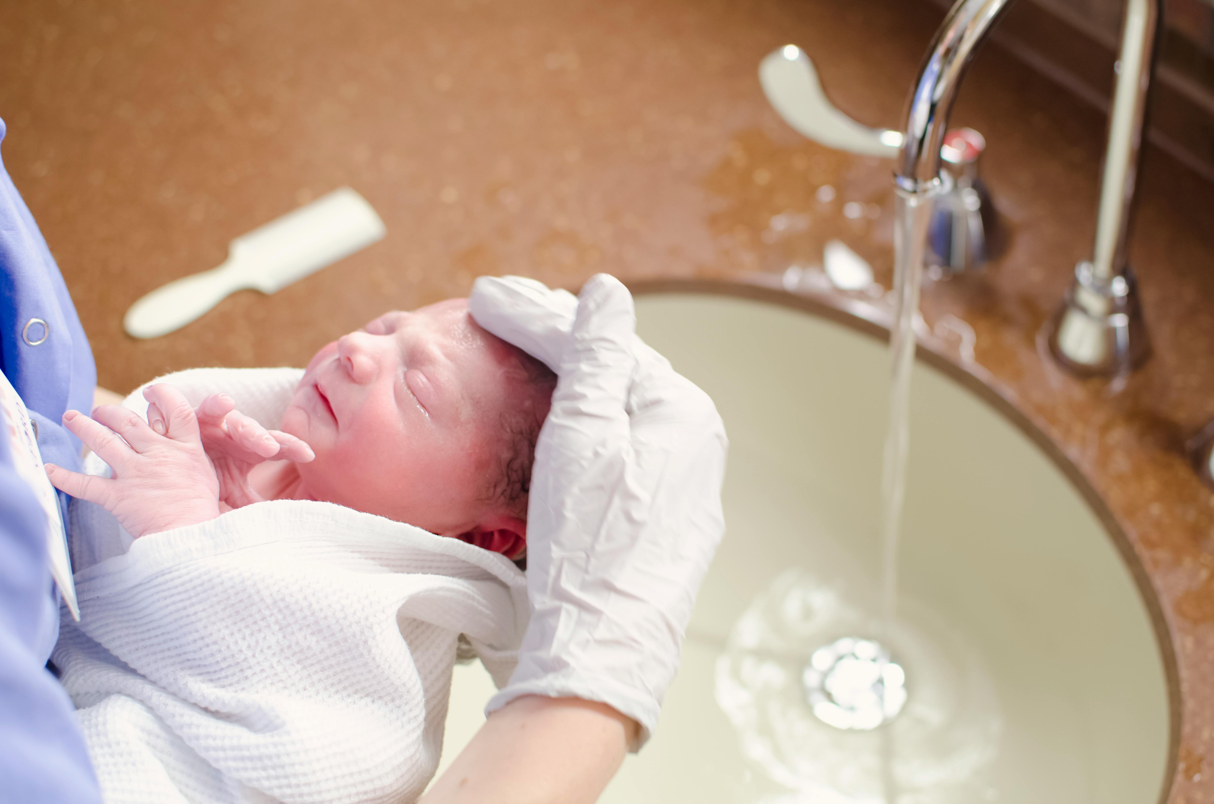Mother bathing newborn